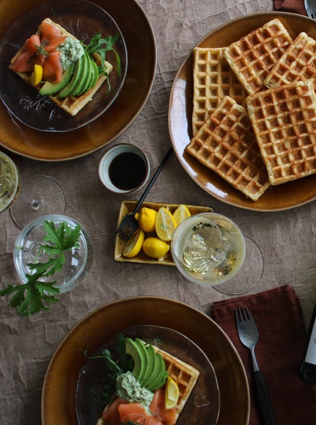 Uppdukat bord med enkla belgiska våfflor med lax och avokado
