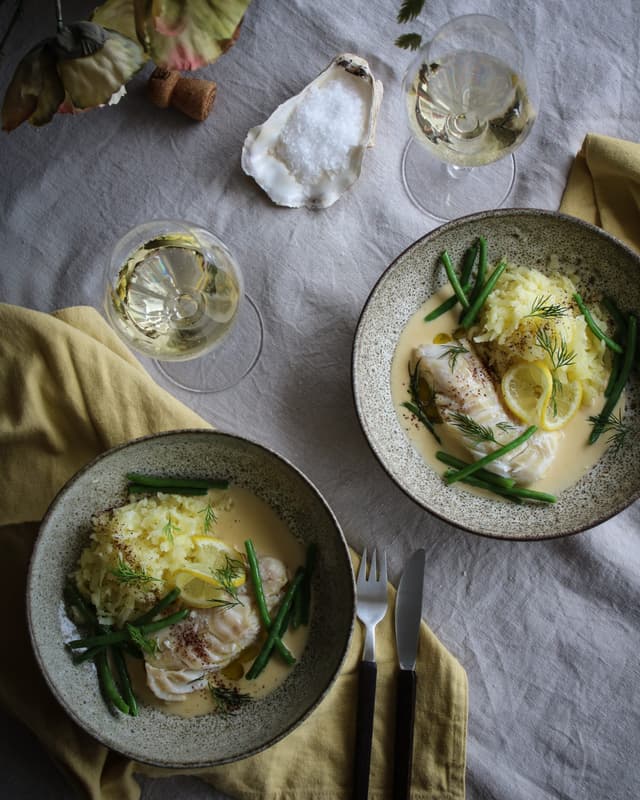 Pocherad torsk serverad med pressad potatis, citronsås och haricots verts.