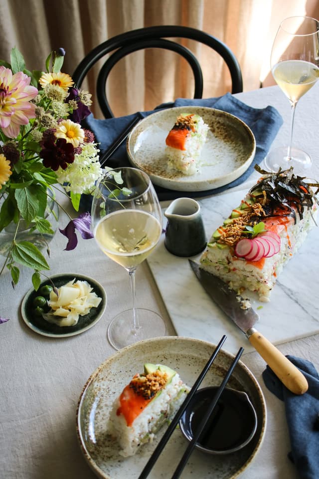 En sushi-tårta med ett glas mousserande vin Brot Cava.