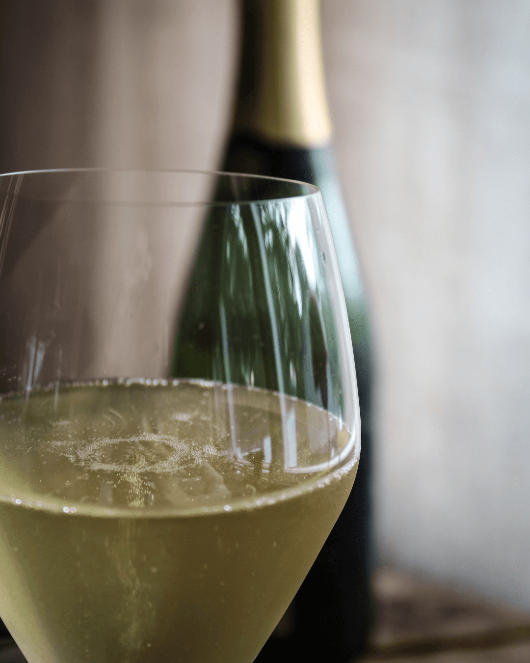 Glas fyllt med champagne tillsammans med en flaska champagne Palmer & Co.