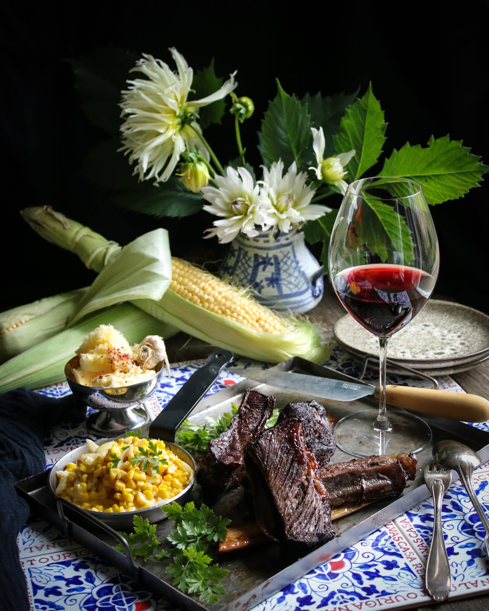 Möra short ribs serverade med creamed corn och vitlökssmör.