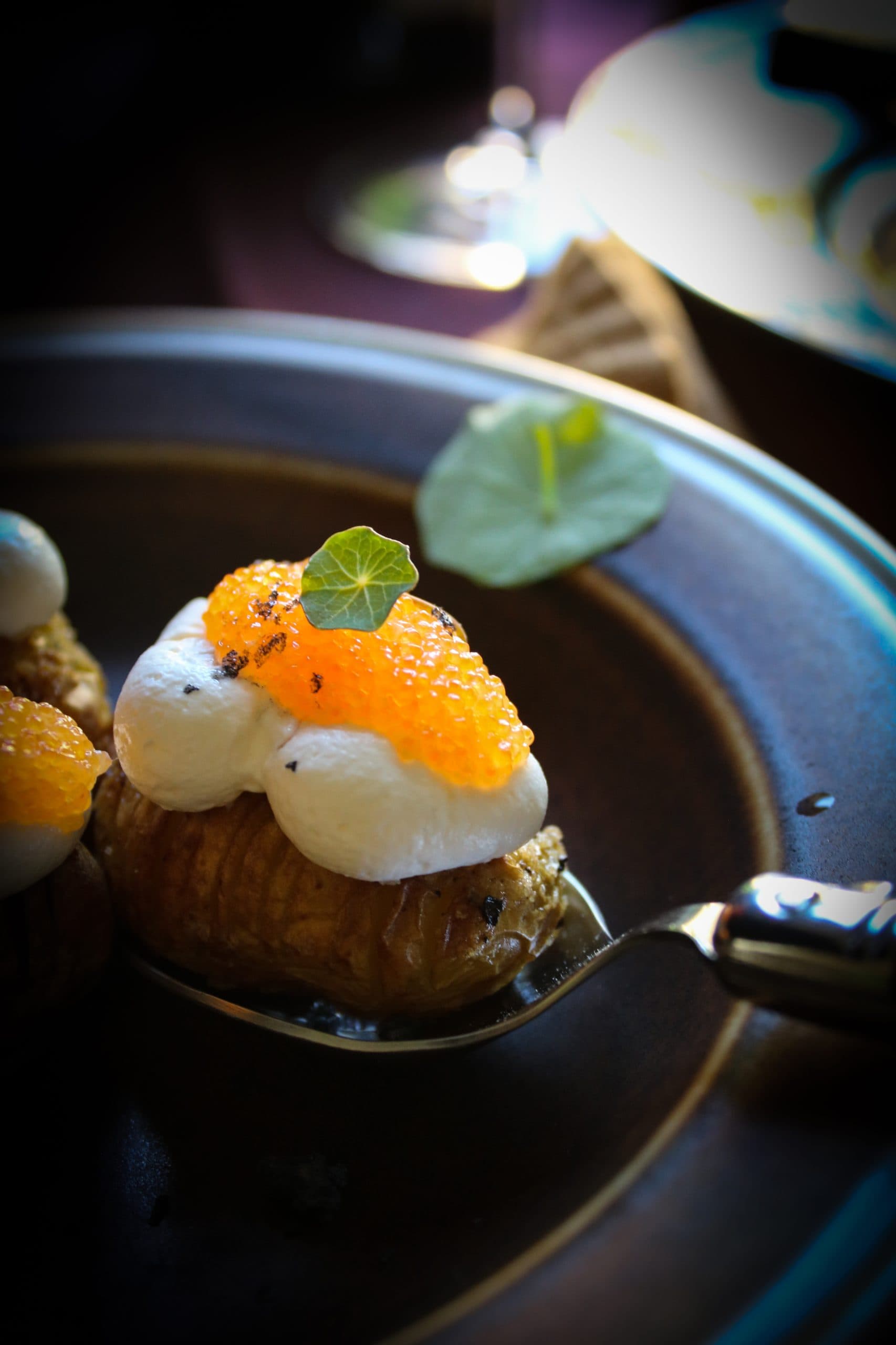 Små, gyllene hasselbackspotatisar toppas med len crème fraiche och frisk rom.