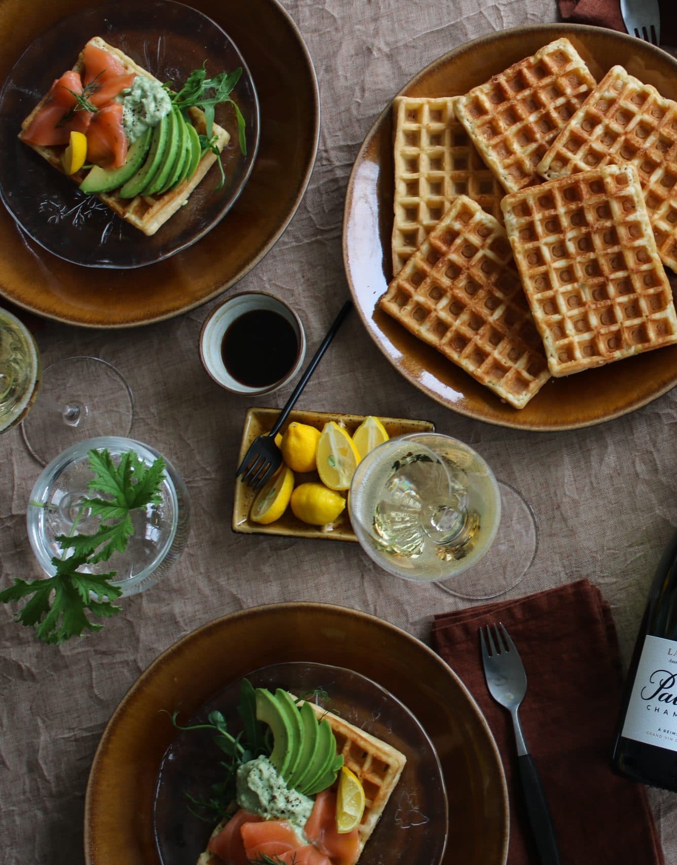 Uppdukat bord med enkla belgiska våfflor med lax och avokado