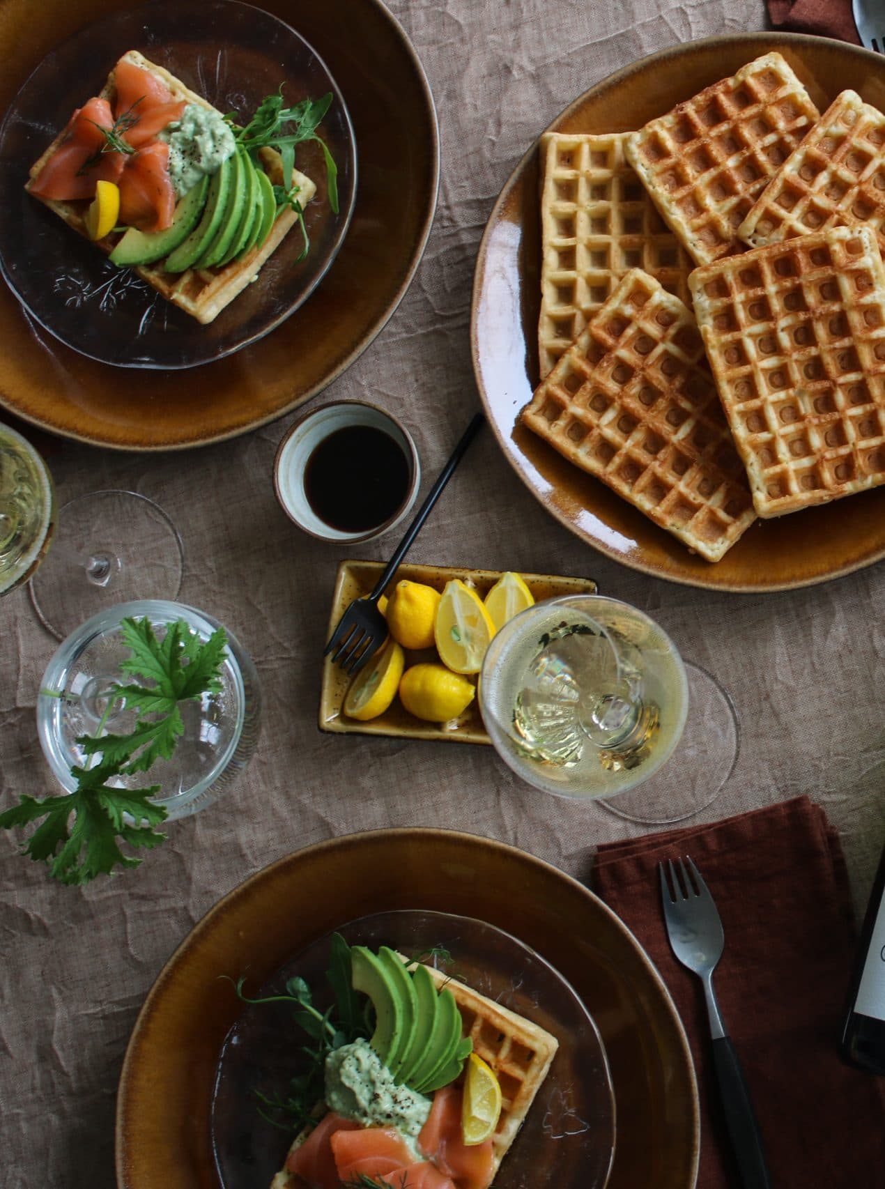 Uppdukat bord med enkla belgiska våfflor med lax och avokado