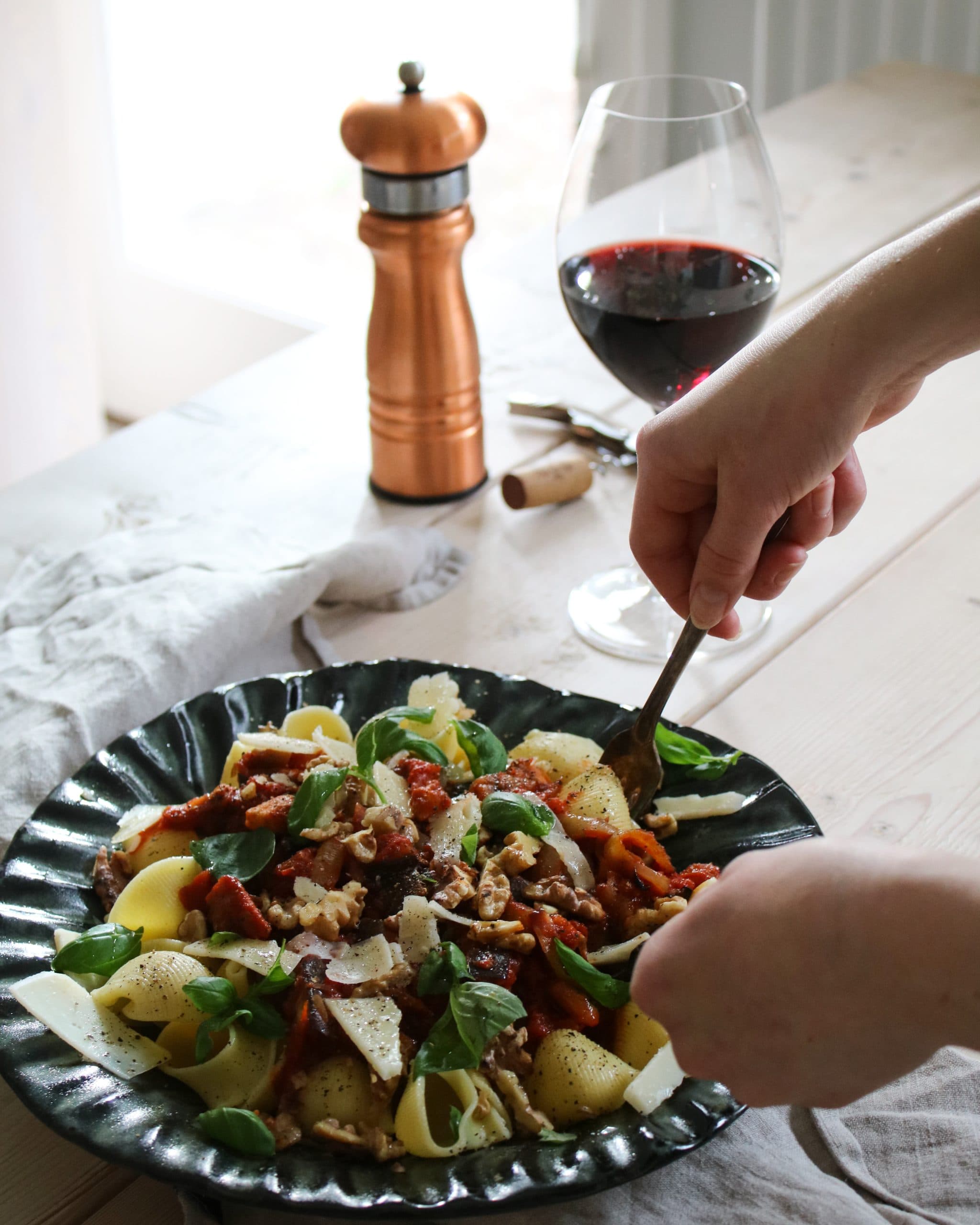 Tagliatelle serverad med ragu på rökig aubergine och valnötter, toppad med örter och riven ost.